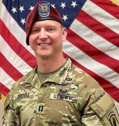Man in US army uniform with US flag in background